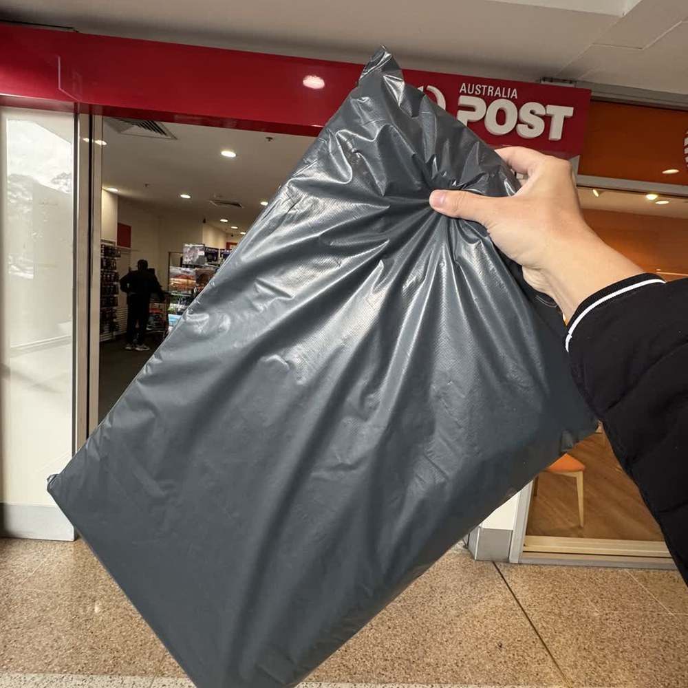 A grey satchel of shades being lodged at an Australia Post counter