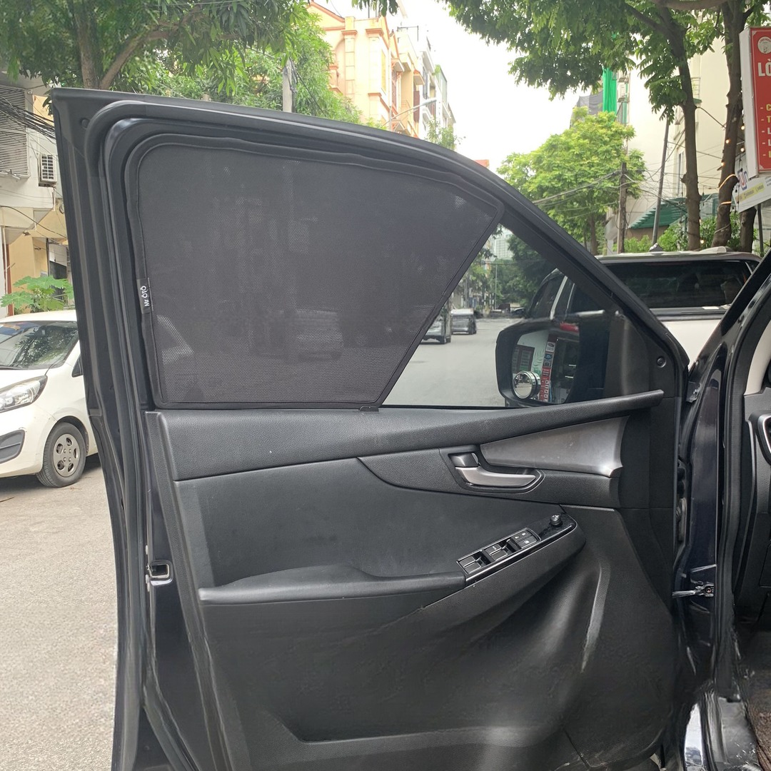 Front door of a 2021-2025 Mazda BT-50, door open, with a mesh shade fitted over the door glass