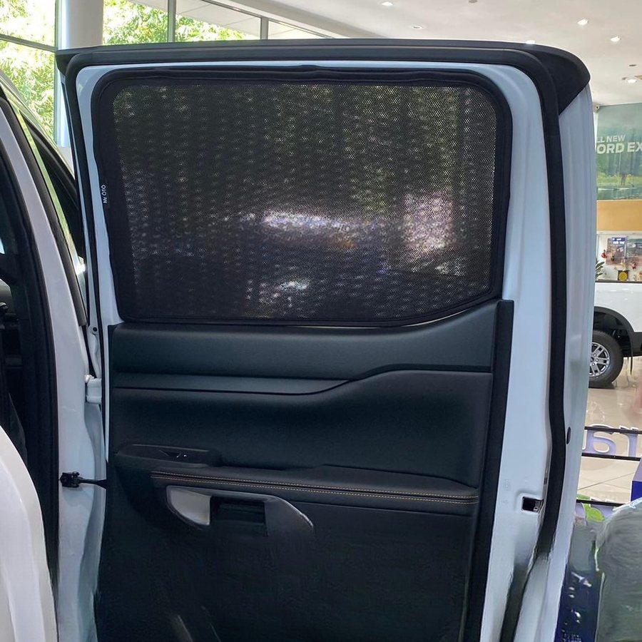 A magnetic sun shade fitted to a front door window, seen from inside the car
