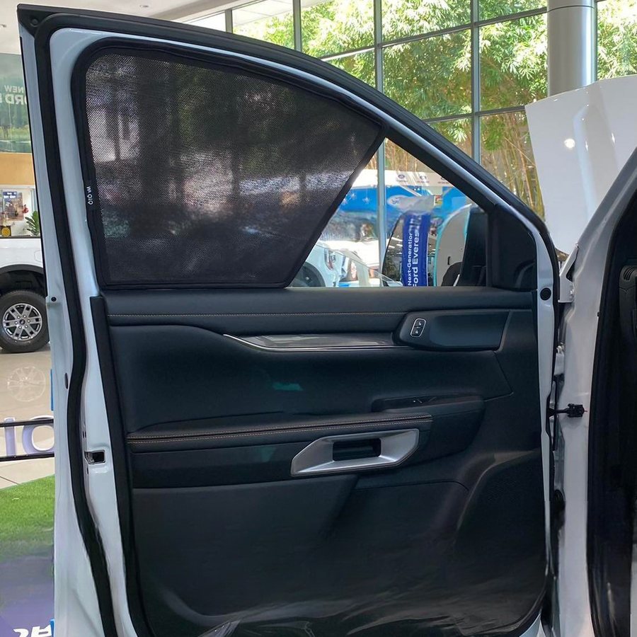 A magnetic sun shade sitting flush inside a rear door window